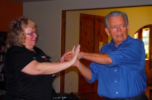 Using Jan Sullivan as a would-be attacker, John Hughes demonstrates how easily fingers can be broken and how effective this would be to ward off an attack when someone grabs you from behind.
