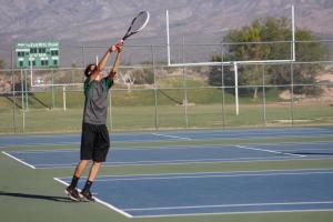 Tyler Hughes Bulldog top seed serving against a Roadrunner opponent Monday afternoon. Photo by Lou Martin.