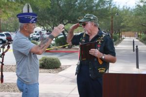 Veteran and Mayor Al Litman salutes and presents fellow veteran Pete Blair a plaque honoring Blair as the 2014 Veterans Day parade Grand Marshall. Photo by Lou Martin