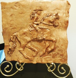 Tammy Symons created a horse and rider in bas relief sculpture, inspired by her own poem about competitive barrel racing.