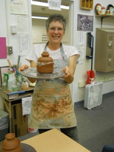 Janet Reynolds shows off her pottery. Photo by Linda Faas.