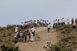 In a reenactment of church lore, angels in white descend from the top of Angel’s Hill to help pull handcarts to the top of the steepest slope during a four-day desert trek through the mountains south of Bunkerville and Mesquite. Photo by Barbara Ellestad. 