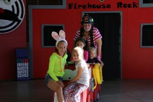 Firefighter AprilLynn LeBaron helps some of the younger breakfast attendees with a ride in their miniature fire truck that is used for their Fire Prevention Program in Mesquite. Photo by Stephanie Clark.  