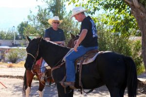 Council members Craig Hafen and George Rapson mount their steeds and get a good feel for the saddles before the start of the 2016 Mesquite Veteran’s Day Parade. Photo by Teri Nehrenz